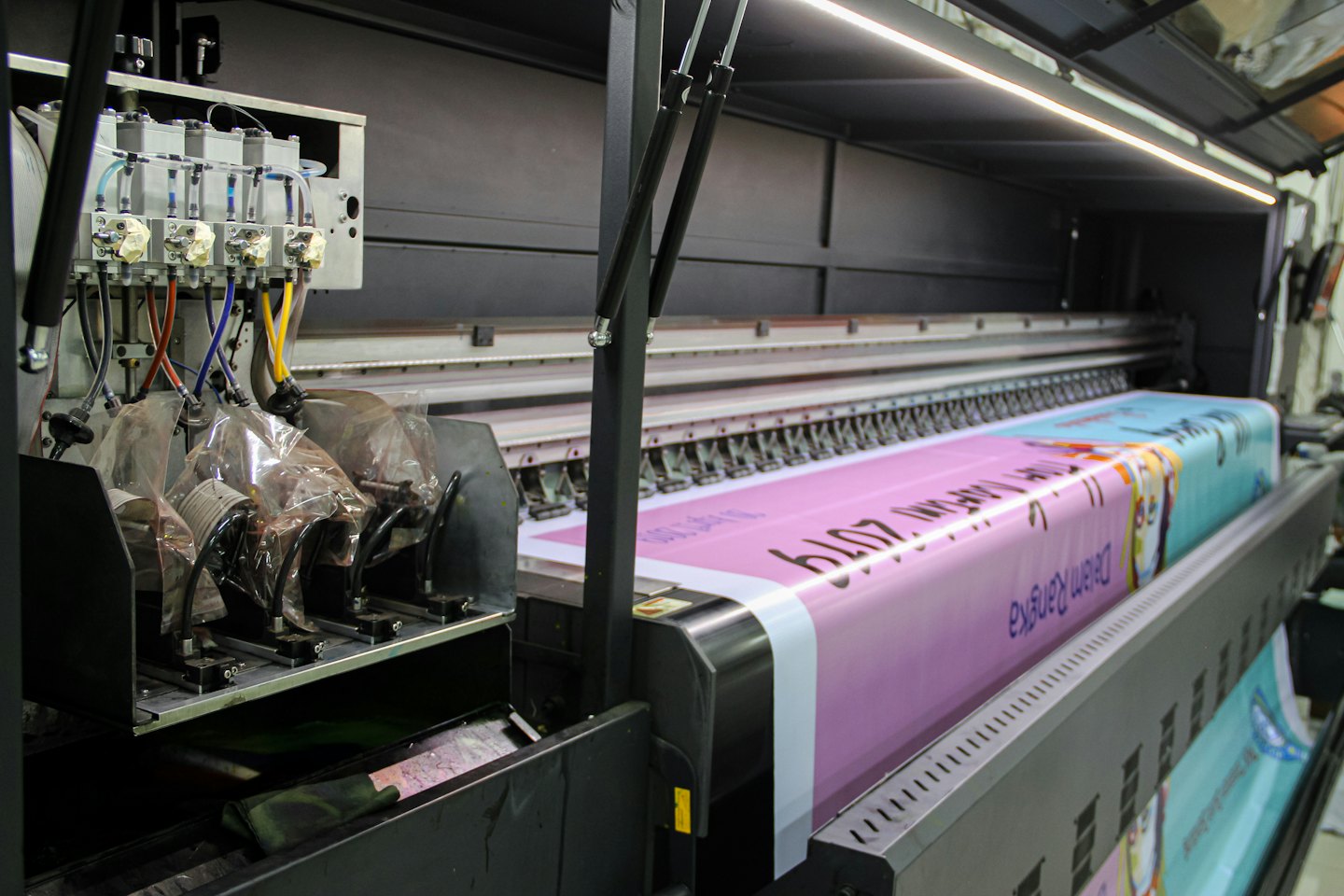 Stampante industriale crea un banner colorato in un laboratorio.